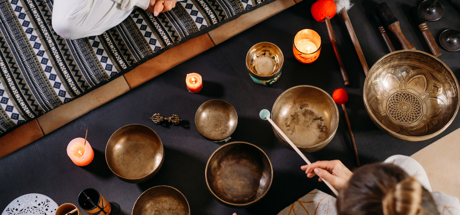 Singing bowls, candles and ceremony mat in soft light